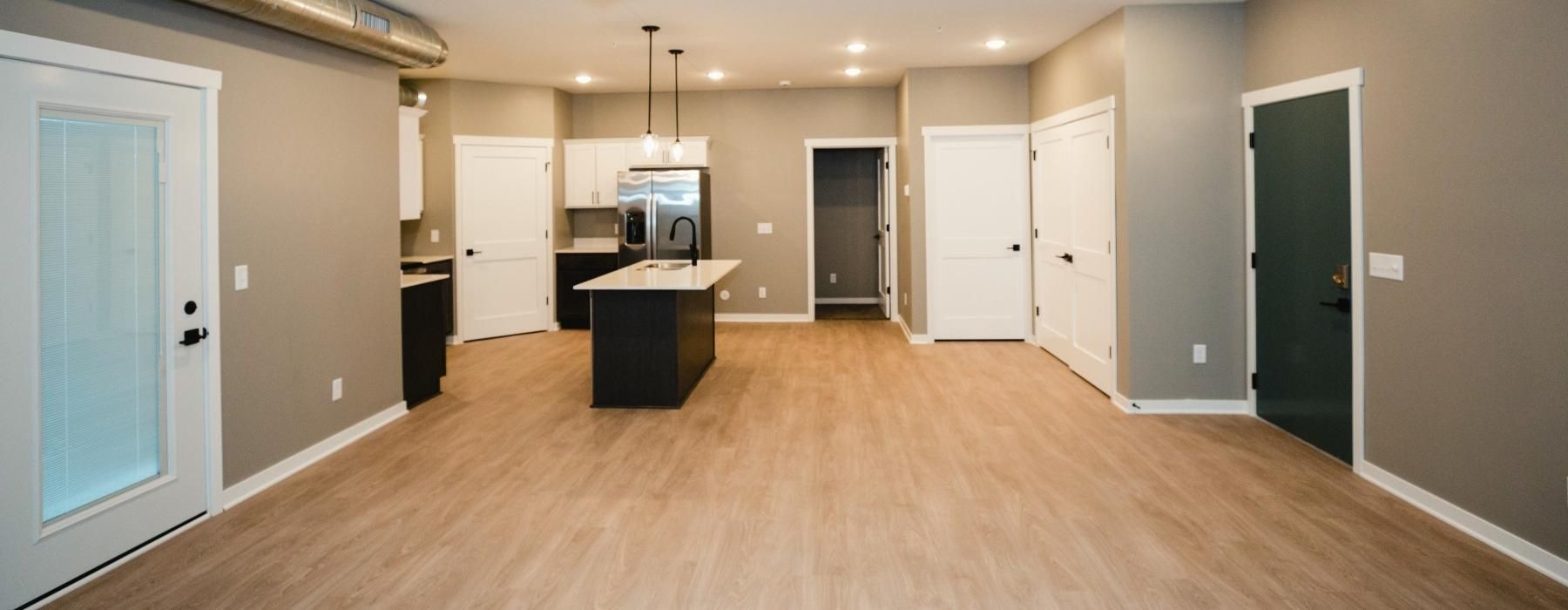 a large empty room with white cabinets